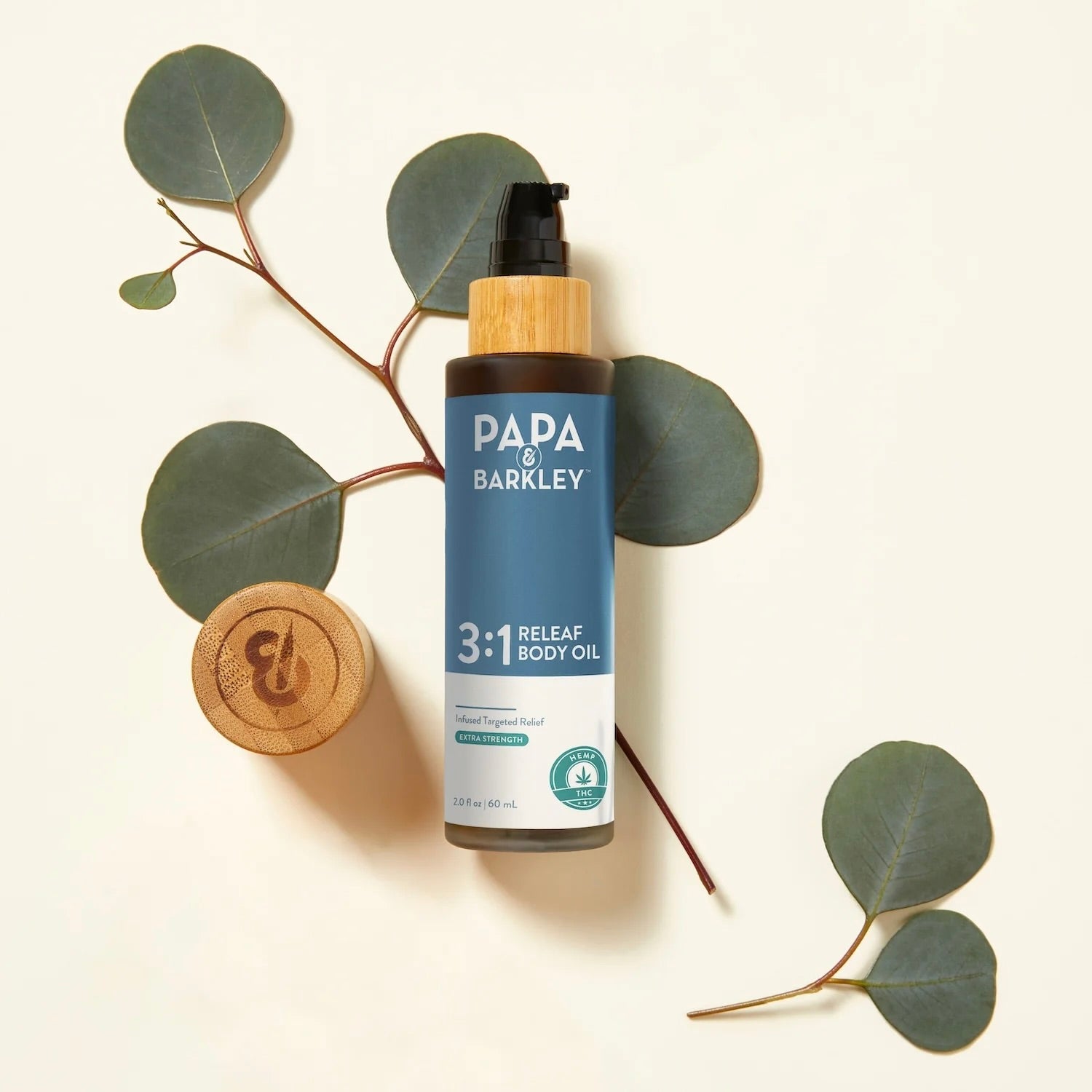 Papa Barkley 3:1 Releaf Body Oil bottle with eucalyptus leaves on a light background